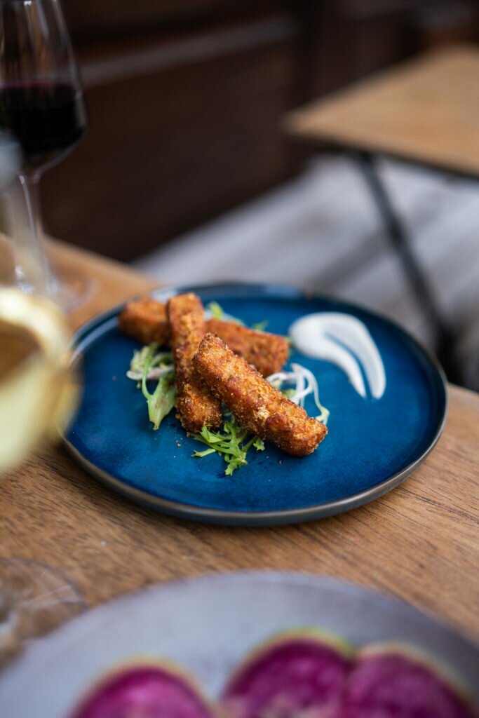 Depuis 2018, nous avons fait voyager des milliers de papilles avec notre cuisine africaine authentique et innovante. Nous sommes un restaurant bistronomique africain à Paris, où la nourriture est notre passion. Inspirés de différentes régions d'Afrique, nos plats savoureux sont préparés avec soin et amour. Nous sommes fiers de vous accueillir dans une ambiance chaleureuse, conviviale et attentionnée. Nous mettons un point d'honneur à vous considérer comme unique et méritant un service impeccable. Notre expérience et notre savoir-faire sont à votre disposition pour vous faire vivre un repas inoubliable. Intégrez notre grande famille en réservant dès maintenant pour (re)découvrir l'Afrique à travers nos assiettes ! Notre restaurant africain bistronomique à Paris vous propose une expérience culinaire unique en fusionnant les saveurs traditionnelles de la cuisine africaine avec une touche innovante de véganisme et de flexitarisme. Nous utilisons des produits de qualité pour offrir une cuisine flexitalienne, adaptée aux coeliaques, sans gluten et végétalienne pour la plupart. Nous sommes également un "black owned business" fier de notre gastronomie et de nos valeurs. Venez découvrir notre cuisine africaine modernisée dans un lieu gourmand et convivial. Venez vivre une expérience culinaire exceptionnelle en dégustant des plats savoureux dans une ambiance chaleureuse. Our bistro-style African restaurant in Paris offers a unique culinary experience by fusing traditional African flavors with an innovative touch of veganism and flexitarianism. We use high-quality products to provide a flexitalian cuisine that is gluten-free, suitable for celiacs, and vegan for the most part. As a proud black-owned business, we celebrate our African gastronomy and values. Come and discover our modernized African cuisine in a cozy and convivial setting. Experience exceptional culinary delights by indulging in our tasty dishes and immerse yourself in a warm ambiance.